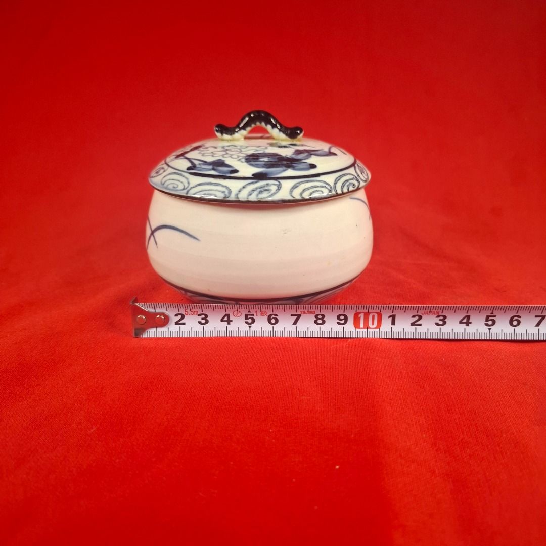 Japanese Blue and White mini Ceramic Lidded Bowl Jar (Category: Vases & Decorative Bowls) located in Mandaluyong City. Submitted by edward123_andren (Listing ID 1464708607, Image 3). Description: - Hand-painted ceramic jar with matching lid - Traditional blue floral and swirl pattern on cream-white background - Features a dark painted handle on top - Compact size: approximately 10cm wide - Versatile use: ideal for small trinkets, kitchen spices, 