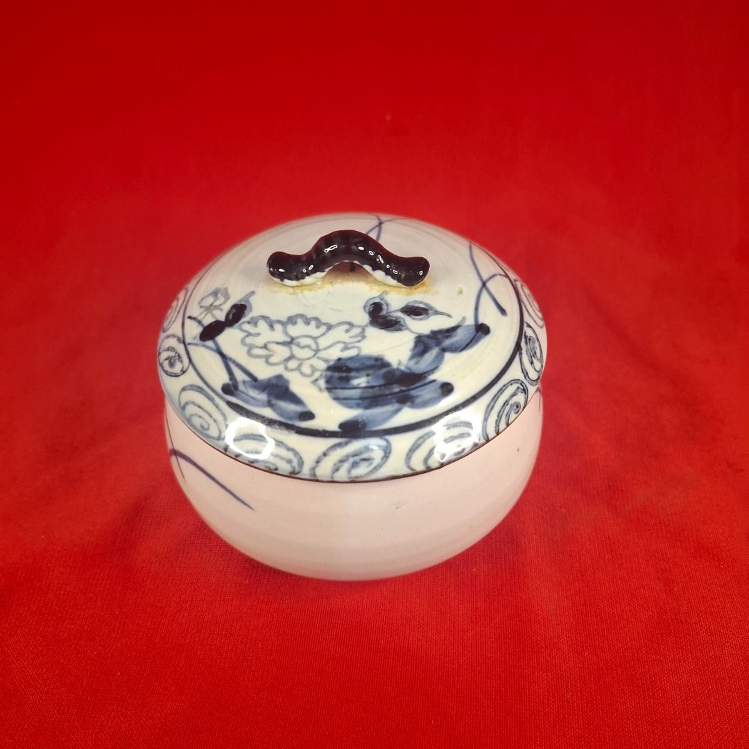 Japanese Blue and White mini Ceramic Lidded Bowl Jar (Category: Vases & Decorative Bowls) located in Mandaluyong City. Submitted by edward123_andren (Listing ID 1464708607, Image 2). Description: - Hand-painted ceramic jar with matching lid - Traditional blue floral and swirl pattern on cream-white background - Features a dark painted handle on top - Compact size: approximately 10cm wide - Versatile use: ideal for small trinkets, kitchen spices, 