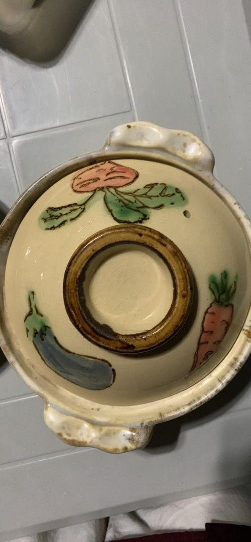 Japanese Ceramic Donabe Clay Pot with Vegetable Illustrations (Category: Cookware & Accessories) located in Manila. Submitted by kashklent0 (Listing ID 1464720739, Image 2). Description: - Hand-painted donabe clay pot with charming carrot, eggplant, and radish lid illustrations - Medium size, ideal for stews and cozy - hot pot nights at home - Double-handled design with a matching lid and steam vent hole - Bottom shows normal signs of previous st