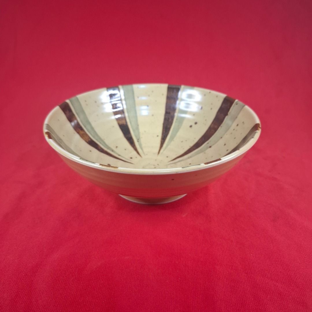Japanese Ceramic Rice Bowl with Striped Pattern (Category: Dinnerware & Cutlery) located in Mandaluyong City. Submitted by edward123_andren (Listing ID 1464708051, Image 2). Description: - Material: Ceramic with a cream-colored base and speckled finish - Design: Japanese minimalist style featuring a striped interior with brown and green brush strokes - Features: Small raised foot on the bottom for stability - Versatile Use: Ideal for rice, soup, 