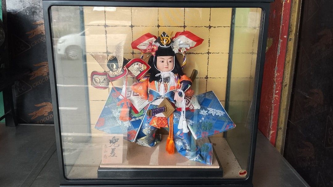 Japanese Samurai Doll in Display Case (Category: Vintage Collectibles) located in Quezon City. Submitted by jpnvintageonline (Listing ID 1464597189, Image 1). Description: - Beautiful Japanese doll dressed as a samurai. - Comes in a protective display case with a gold patterned background. - Doll wears a colorful kimono and traditional headwear. - Includes a small wooden plaque with Japanese writing at the base. - Display case measures approximat