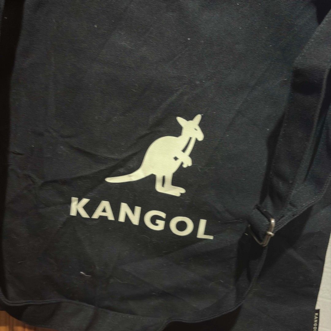 Kangol Black Canvas Tote Bag (Category: Tote Bags) located in Carmen. Submitted by ar_thrift00 (Listing ID 1464715206, Image 2). Description: - Brand: Kangol - Color: Classic Black with large white kangaroo logo - Material: 100% Cotton Canvas - Closure: Secure snap button - Storage: Roomy main compartment with inner pocket - Versatility: Includes top carry handles and an adjustable shoulder strap - Model: KOEB-EB00370 - Condition: Excellent every