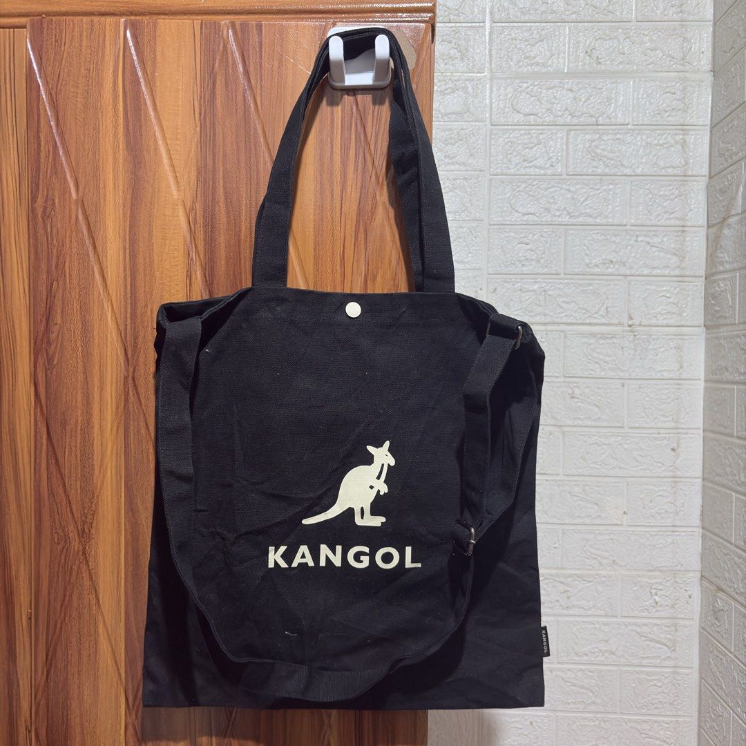 Kangol Black Canvas Tote Bag with Shoulder Strap (Category: Tote Bags) located in Carmen. Submitted by rr_thrifts (Listing ID 1464720150, Image 1). Description: - Authentic Kangol canvas tote bag in classic black - Heavy-duty, durable material ideal for daily use, school, or errands - Features a large white Kangol kangaroo logo and lettering on the front - Dual carry handles and a convenient adjustable shoulder strap included - Secure snap button