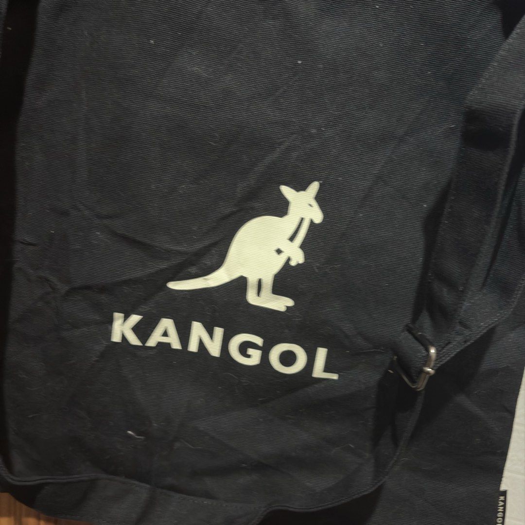 Kangol Black Canvas Tote Bag with Shoulder Strap (Category: Tote Bags) located in Carmen. Submitted by rr_thrifts (Listing ID 1464720150, Image 2). Description: - Authentic Kangol canvas tote bag in classic black - Heavy-duty, durable material ideal for daily use, school, or errands - Features a large white Kangol kangaroo logo and lettering on the front - Dual carry handles and a convenient adjustable shoulder strap included - Secure snap button