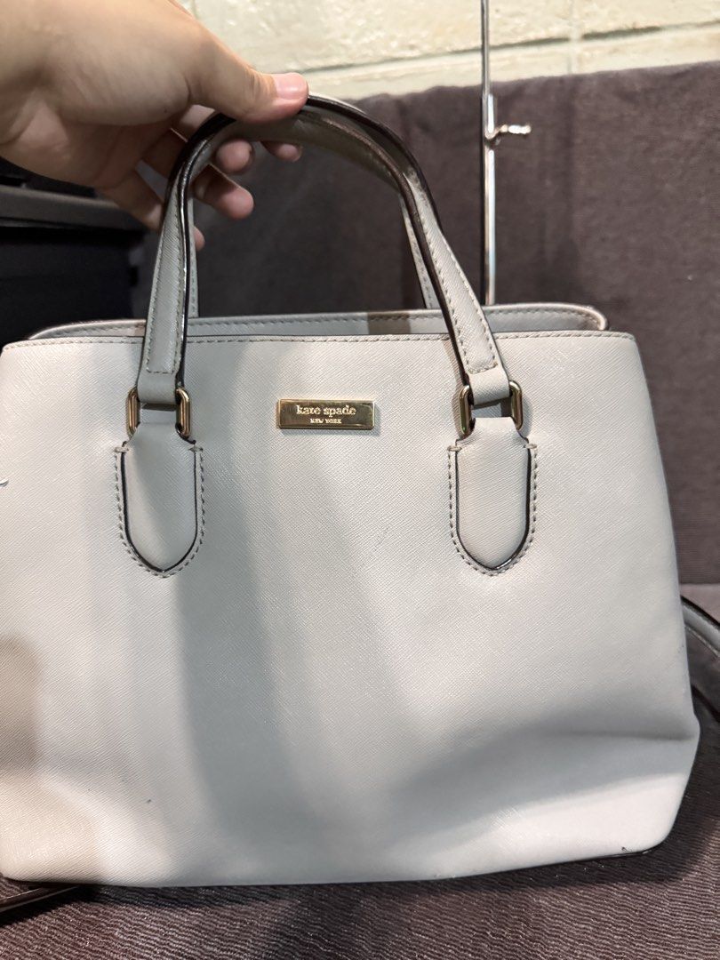 Kate Spade Light Grey Leather Satchel Handbag (Category: Tote Bags) located in Manila. Submitted by dearpinkcollections (Listing ID 1464680713, Image 2). Description: - Light grey Kate Spade satchel - Genuine saffiano leather - Elegant gold hardware details - Multiple interior compartments and a zip pocket - Small mark on the front (visible in photos) and may maliit na kurot hindi naman mapapansin sa malayo - Comes with a detachable shoulder stra