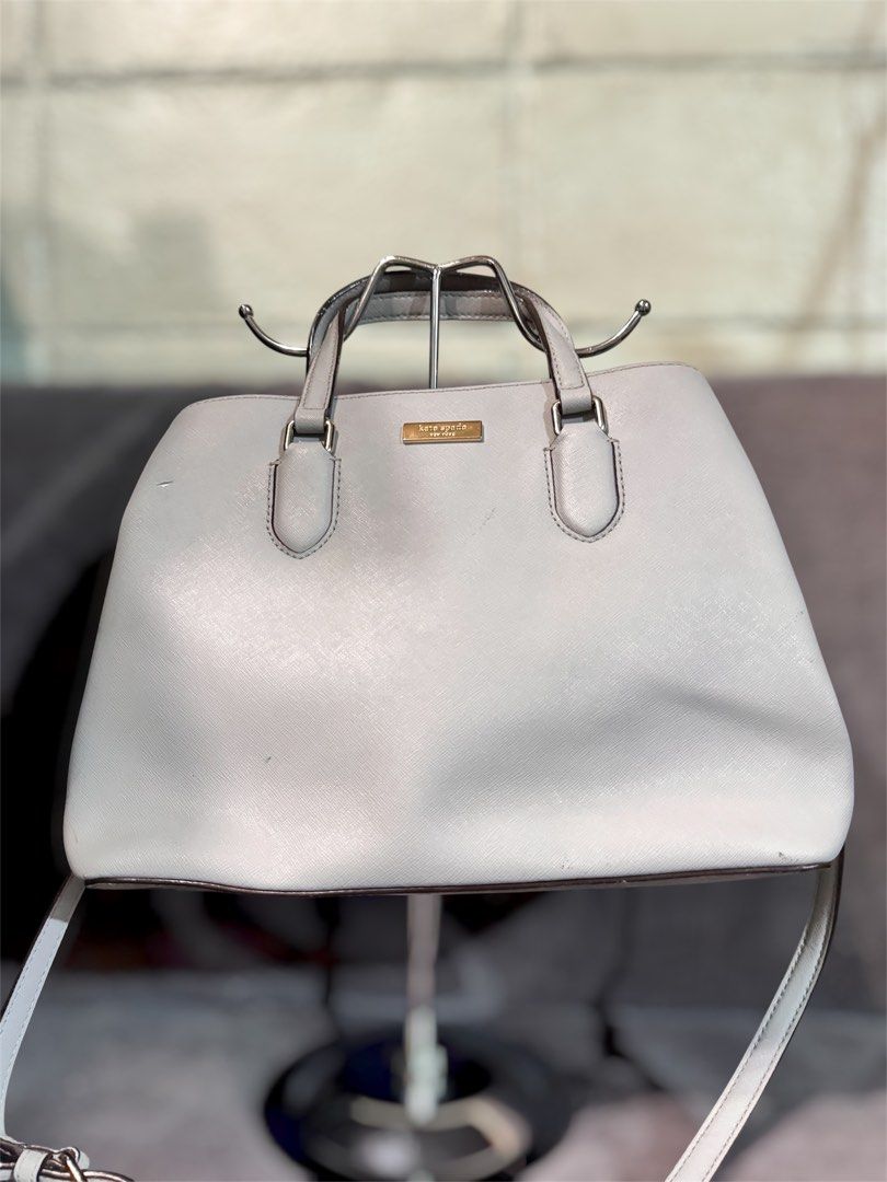 Kate Spade Light Grey Leather Satchel Handbag (Category: Tote Bags) located in Manila. Submitted by dearpinkcollections (Listing ID 1464680713, Image 1). Description: - Light grey Kate Spade satchel - Genuine saffiano leather - Elegant gold hardware details - Multiple interior compartments and a zip pocket - Small mark on the front (visible in photos) and may maliit na kurot hindi naman mapapansin sa malayo - Comes with a detachable shoulder stra