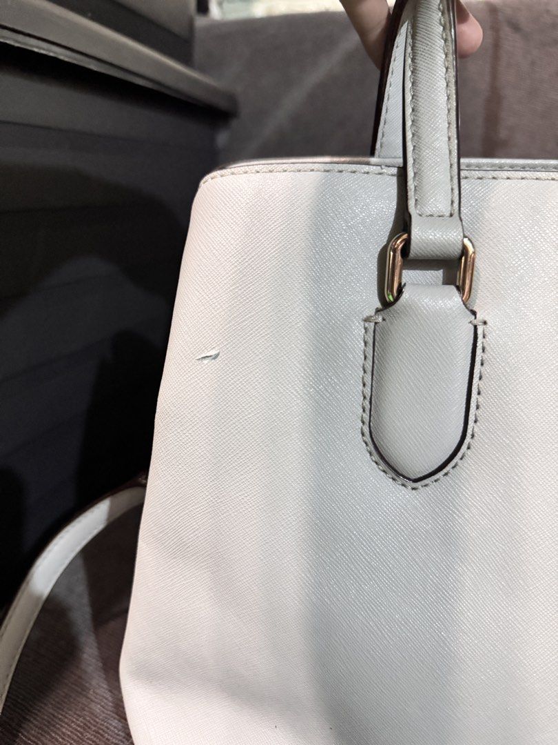Kate Spade Light Grey Leather Satchel Handbag (Category: Tote Bags) located in Manila. Submitted by dearpinkcollections (Listing ID 1464680713, Image 3). Description: - Light grey Kate Spade satchel - Genuine saffiano leather - Elegant gold hardware details - Multiple interior compartments and a zip pocket - Small mark on the front (visible in photos) and may maliit na kurot hindi naman mapapansin sa malayo - Comes with a detachable shoulder stra