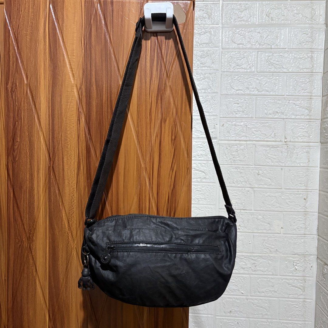 Kipling Black Crossbody Bag with Monkey Keychain (Category: Cross-body Bags) located in Carmen. Submitted by rr_thrifts (Listing ID 1464719112, Image 1). Description: - Authentic black Kipling crossbody bag made from durable, lightweight crinkled nylon - Adjustable shoulder strap for a comfortable, customized fit - Convenient zippered outer pocket on the front for easy access to essentials - Includes the iconic and playful black Kipling monkey ke