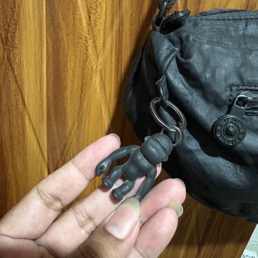 Kipling Black Crossbody Bag with Monkey Keychain (Category: Cross-body Bags) located in Carmen. Submitted by rr_thrifts (Listing ID 1464719112, Image 3). Description: - Authentic black Kipling crossbody bag made from durable, lightweight crinkled nylon - Adjustable shoulder strap for a comfortable, customized fit - Convenient zippered outer pocket on the front for easy access to essentials - Includes the iconic and playful black Kipling monkey ke