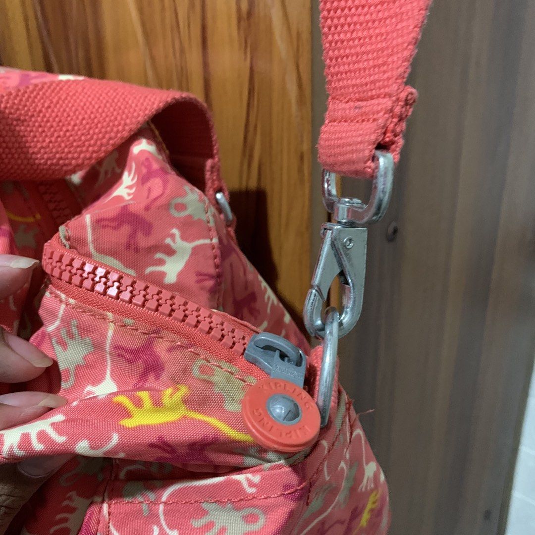 Kipling Monkey Print Pink Duffel Bag (Category: Shoulder Bags) located in Carmen. Submitted by rr_thrifts (Listing ID 1464730543, Image 3). Description: - Authentic pink Kipling duffel bag with cute monkey print graphics - Front zipper pocket with iconic round Kipling logo patch - Thick coral pink canvas carry straps and matching adjustable shoulder strap with metal clasps - Smooth-running zippers featuring signature round logo pulls - Flaw: Mino