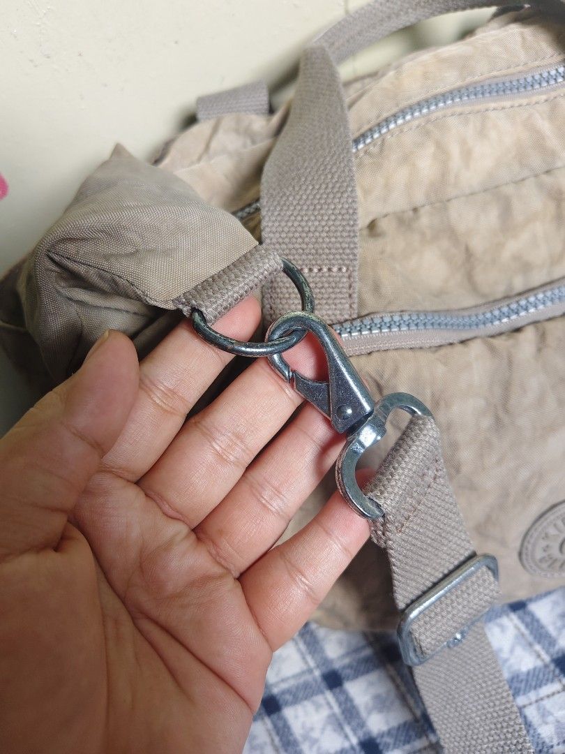 Kipling Shoulder Bag Tan Nylon (Category: Shoulder Bags) located in General Mariano Alvarez. Submitted by findsandmoreph (Listing ID 1464572295, Image 3). Description: - Tan Kipling shoulder bag - Made of durable crinkled nylon - Two comfortable top handles - Detachable shoulder strap for versatile carrying - Multiple zippered pockets on the front for organized storage - Iconic Kipling monkey charm included - Ideal everyday bag for your essential