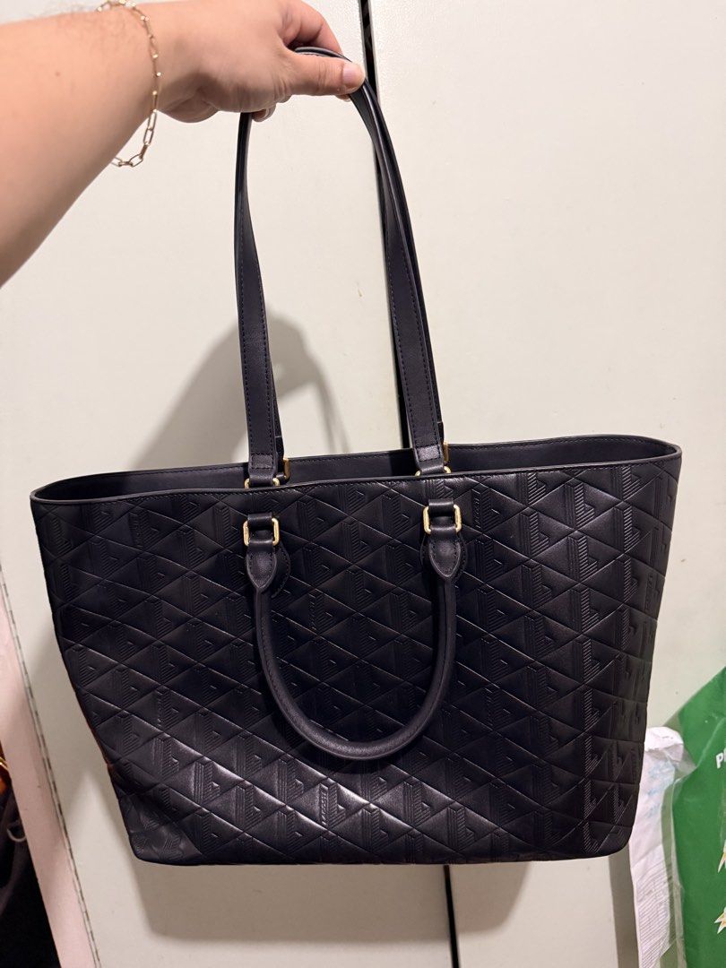 Lacoste Black Embossed Tote Bag (Category: Tote Bags) located in San Juan City. Submitted by zenrabbit.6105c7 (Listing ID 1464691460, Image 3). Description: Black Lacoste tote bag with geometric embossed pattern all over. Dual shoulder straps, gold-tone hardware. Interior lined in light canvas fabric with zippered pocket carrying the Lacoste brand patch. Structured everyday bag, roomy enough for daily essentials..