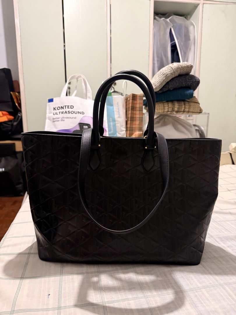 Lacoste Black Embossed Tote Bag (Category: Tote Bags) located in San Juan City. Submitted by zenrabbit.6105c7 (Listing ID 1464691460, Image 1). Description: Black Lacoste tote bag with geometric embossed pattern all over. Dual shoulder straps, gold-tone hardware. Interior lined in light canvas fabric with zippered pocket carrying the Lacoste brand patch. Structured everyday bag, roomy enough for daily essentials..