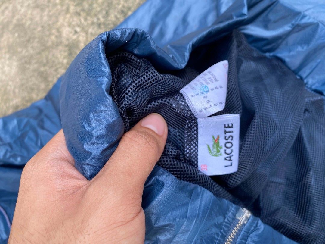 Lacoste Blue Windbreaker Hooded Jacket Size 38 (Category: Coats, Jackets and Outerwear) located in Tangub. Submitted by brightfire_c293e4 (Listing ID 1464741009, Image 2). Description: - Brand: Lacoste - Item: Hooded windbreaker - Color: Blue - Size: Tag size 38 - Material: Lightweight with dark mesh inner lining - Closure: Full zip front with branded metal pullers - Hood: Adjustable drawstring with cord locks - Pockets: Two front zippered pocket
