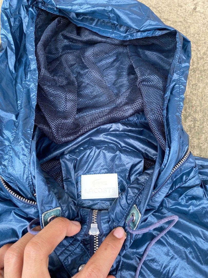 Lacoste Blue Windbreaker Hooded Jacket Size 38 (Category: Coats, Jackets and Outerwear) located in Tangub. Submitted by brightfire_c293e4 (Listing ID 1464741009, Image 3). Description: - Brand: Lacoste - Item: Hooded windbreaker - Color: Blue - Size: Tag size 38 - Material: Lightweight with dark mesh inner lining - Closure: Full zip front with branded metal pullers - Hood: Adjustable drawstring with cord locks - Pockets: Two front zippered pocket