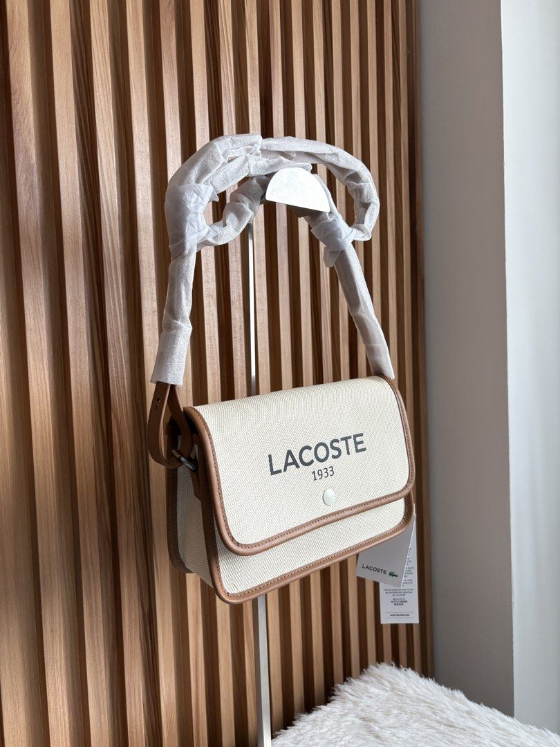 LACOSTE FLAP CROSSOVER BAG IN NATURAL TAN (Category: Cross-body Bags) located in Imus. Submitted by dumpitlikeaqueen (Listing ID 1464712333, Image 2). Description: • Store-bought at Lacoste, Duty Free Fiestamall • With tags, plastic & paper bag • Original Price: 145USD • 2 pcs. on hand • Open for layaway • Instagram Shop: @dumpitlikeaqueen.