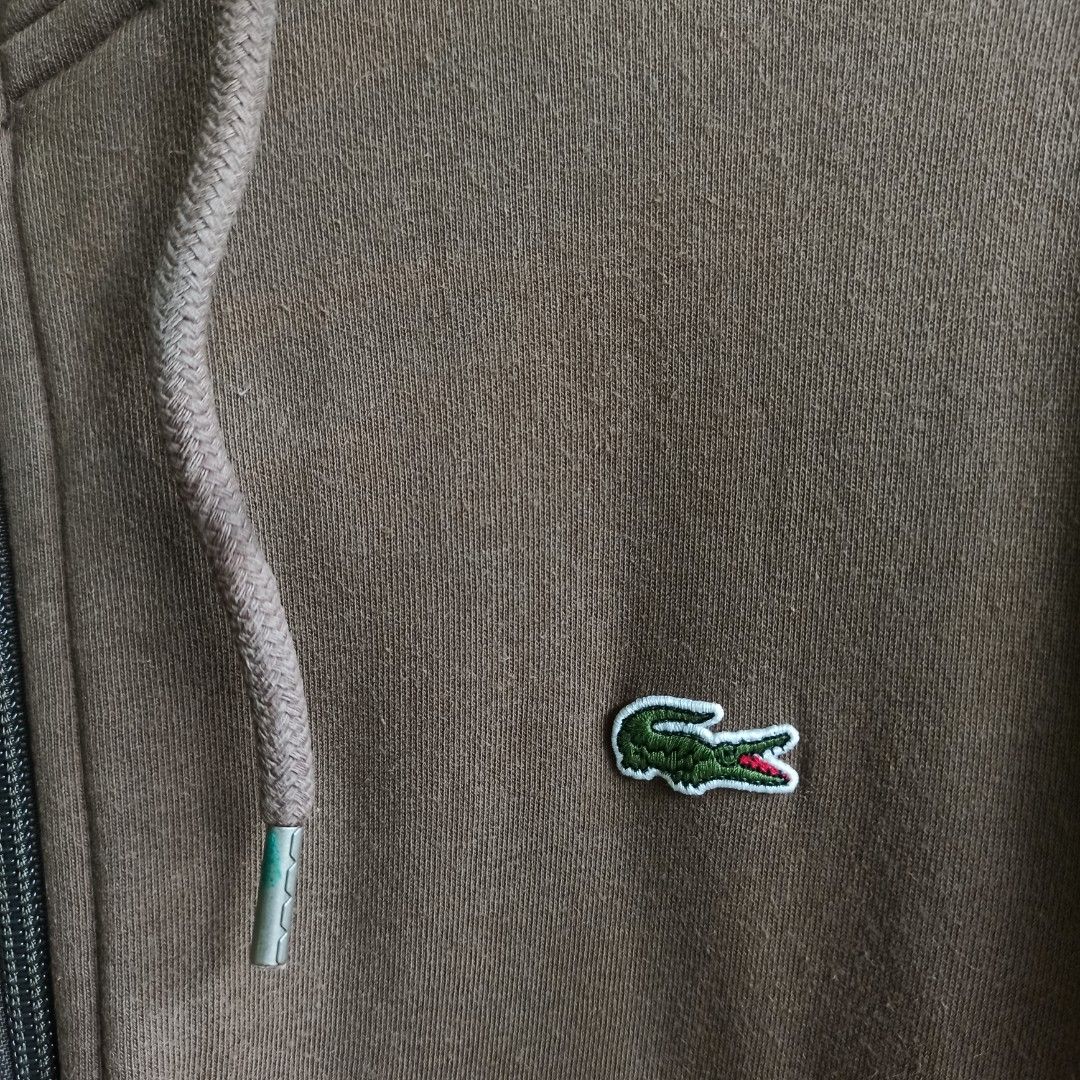 Lacoste Zip-Up Hoodie (Category: Coats, Jackets and Outerwear) located in Tagbilaran City. Submitted by delasierra39181 (Listing ID 1464617496, Image 2). Description: - Brand: Lacoste - Color: Brown - Style: Zip-up Hoodie - Features: Iconic crocodile logo on chest, drawstring hood, front pockets - Size: Tag shows 4 - Ideal for: Casual wear.