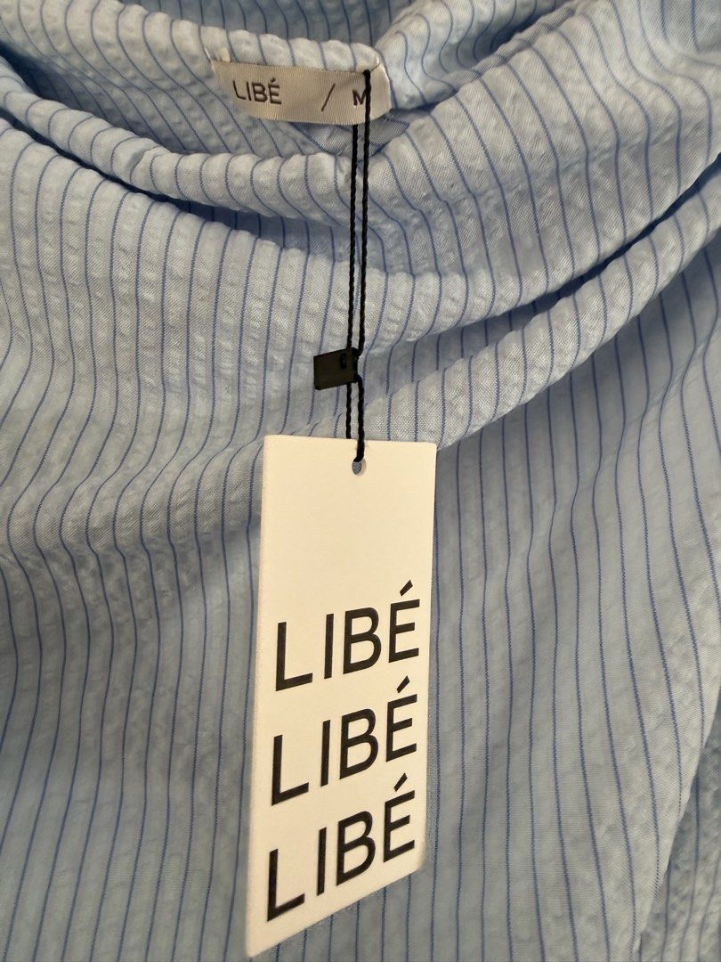 LIBÉ Blue Striped Off Shoulder Top Size M (Category: Sleeveless) located in Iligan City. Submitted by peachylovessoup (Listing ID 1464667247, Image 3). Description: - LIBÉ one-shoulder top - Light blue stripe pattern - Textured fabric - Size: Medium (M) - From the Wanderlust Collection - Pairs well with jeans or skirts - Unique addition to your wardrobe -Bought in HCM -Brand New with tag helping tags: zara, h&m, bershka, rubies, pull&bear, bunnyh