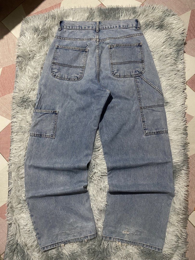 DKNEE CARPENTER BAGGY PANTS (Category: Jeans) located in Mendez-Nunez. Submitted by leighthrift (Listing ID 1464606119, Image 2). Description: WAIST: 30 LENGTH: 40 THIGH: 14 HEM: 10 ISSUE: HEELBITE AND SCRATCHES - Light wash denim jeans - Wide leg fit with carpenter style - Multiple pockets (front and back) - Distressed detailing on the hem - Ideal for casual streetwear - Comfortable and durable.