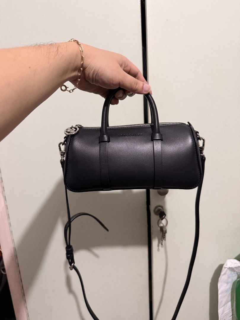 Longchamp Black Leather Crossbody Bag (Category: Luxury Bags & Wallets) located in San Juan City. Submitted by zenrabbit.6105c7 (Listing ID 1464691332, Image 1). Description: - Brand: Longchamp - Material: Premium black leather with silver hardware - Closure: Top zip with round silver pull tab - Straps: Dual top handles + detachable, adjustable shoulder strap - Design: Clean, minimalist style with embossed front logo - Size: Compact and practical