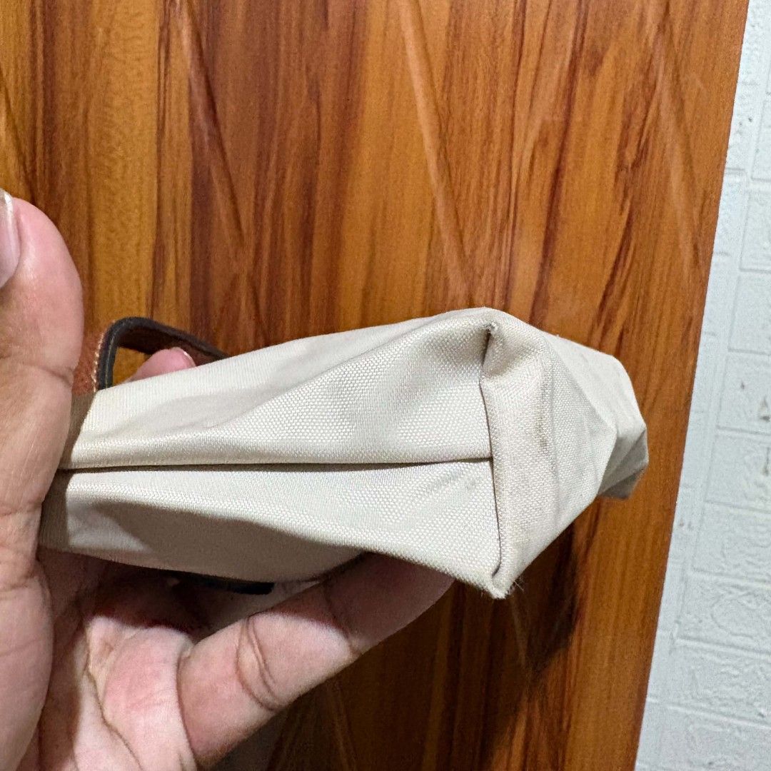 Longchamp Le Pliage Extra Small Mini Top Handle Bag (Category: Purses & Pouches) located in Carmen. Submitted by ar_thrift00 (Listing ID 1464715504, Image 3). Description: - Brand: Longchamp Mini Top Handle Bag - Color: Off-white nylon with brown leather flap - Hardware: Gold-tone with signature horse embossed pull - Closure: Zipper with front snap button flap - Interior: Clean lining with open pocket for organization - Size: Compact, perfect for