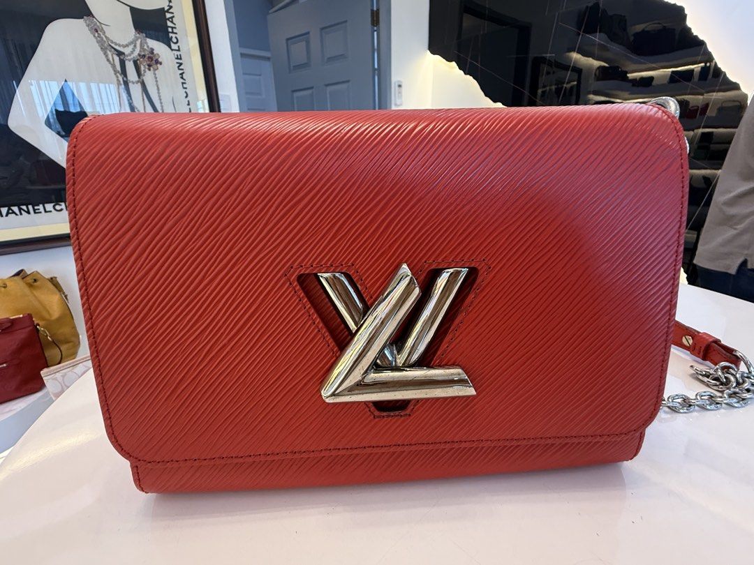 Louis Vuitton Twist MM Epi Leather Red (Category: Luxury Bags & Wallets) located in Alfonso. Submitted by luxurose (Listing ID 1464759572, Image 1). Description: - Brand: Louis Vuitton Twist MM - Material: Textured Epi leather in Bright Red - Hardware: Silver with iconic LV twist lock - Interior: Pink suede lining with matching mirror cutout - Strap: Sliding chain strap for shoulder or crossbody wear - Condition: Clean corners, minor hairline scr