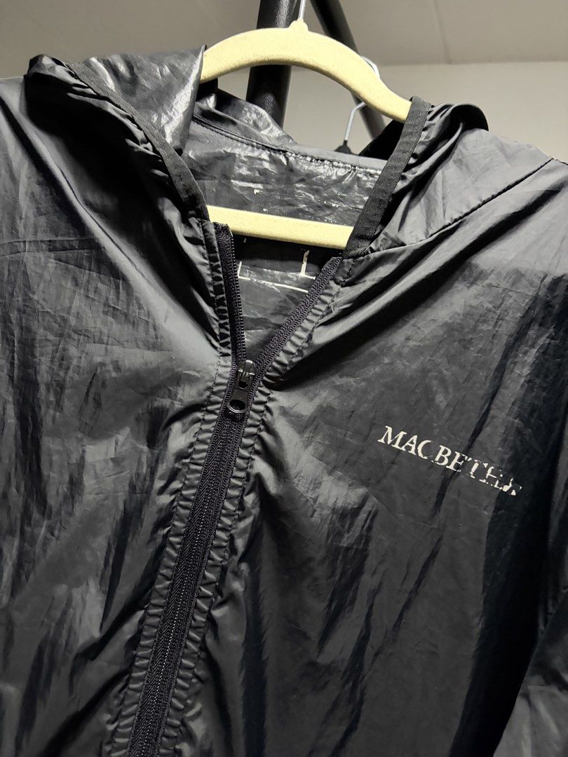 Macbeth Black Hooded Windbreaker Jacket (Category: Coats, Jackets and Outerwear) located in Manila. Submitted by finderskeepersmnl_092026 (Listing ID 1464744336, Image 1). Description: - Brand: Macbeth - Color: Classic black with a small white logo on the left chest - Material: Thin, lightweight, and easily packable into a bag - Features: Full zip closure, attached hood with adjustable drawstrings, and elastic sleeve cuffs - Fit: Regular fit - Be