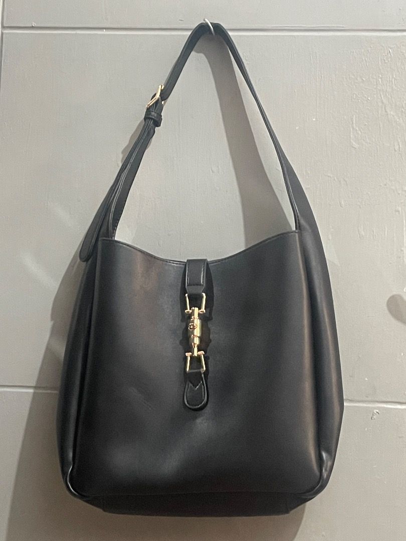 Madison West Shoulder Bag (Category: Shoulder Bags) located in Marikina City. Submitted by bezz_bezzy (Listing ID 1464765113, Image 1). Description: - Color: Black - Material: Smooth faux leather with zero scuffs or scratches - Design: Slouchy yet holds its shape well with a clean minimalist look - Hardware: Distinctive shiny gold piston closure on the front - Strap: Adjustable via side buckle - Condition: Excellent, exterior is flawless.