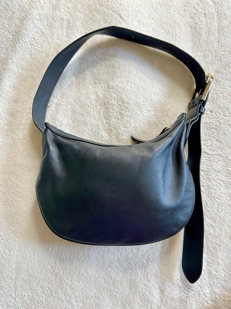 MNG Black Leather Mini Shoulder Bag (Category: Shoulder Bags) located in Carigara. Submitted by abiealberca (Listing ID 1464576286, Image 2). Description: - Brand: Mango (MNG) - Material: Black Genuine Leather (Lamb Skin) - Design: Curved silhouette, classic and simple, adjustable gold buckle - Features: Adjustable shoulder strap with gold buckle, zipper closure - Interior: Lined - Flaws: Minimal sign of usage, tag removed - Use: Great for everyd
