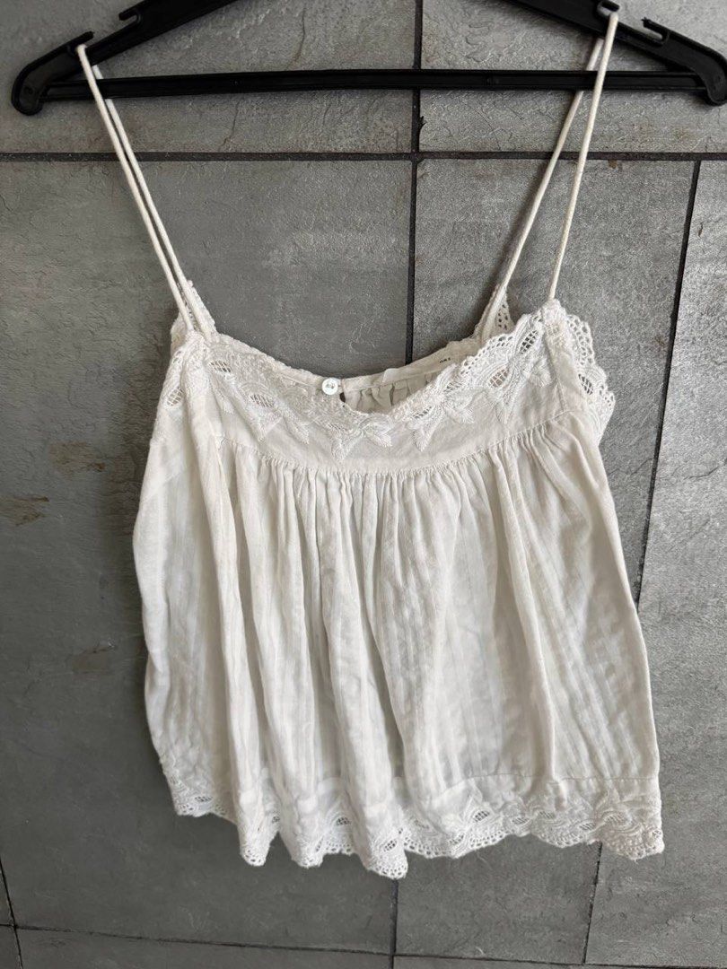Mango Casual White Lace Trim Cami Top Size S (Category: Sleeveless) located in Taguig. Submitted by anxmz (Listing ID 1464676202, Image 1). Description: - White cami top from Mango - Features delicate lace trim on neckline and hem - Thin, adjustable straps - Gathered bust detail with a small button - Lightweight fabric with subtle vertical stripes - Perfect for layering or wearing solo.