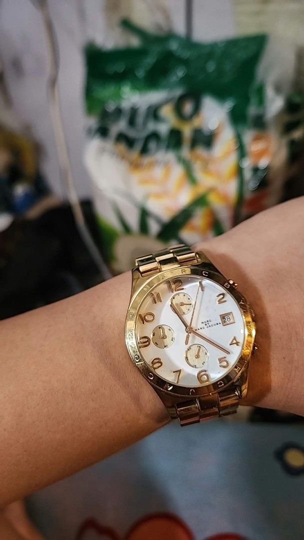 Marc by Marc Jacobs Gold Chronograph Watch (Category: Women's Watches) located in Manila. Submitted by jialyn03310_tree (Listing ID 1464637583, Image 1). Description: - Brand: Marc by Marc Jacobs - Color: Gold tone - Dial: White with gold hour markers and hands - Features: Chronograph function, date display - Strap: Bracelet with deployant clasp - Water Resistance: 5 ATM - Condition: Minor signs of wear on the bracelet.