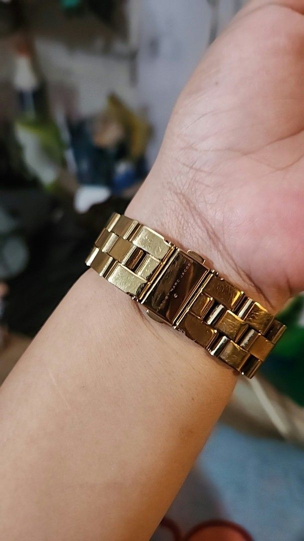 Marc by Marc Jacobs Gold Chronograph Watch (Category: Women's Watches) located in Manila. Submitted by jialyn03310_tree (Listing ID 1464637583, Image 2). Description: - Brand: Marc by Marc Jacobs - Color: Gold tone - Dial: White with gold hour markers and hands - Features: Chronograph function, date display - Strap: Bracelet with deployant clasp - Water Resistance: 5 ATM - Condition: Minor signs of wear on the bracelet.