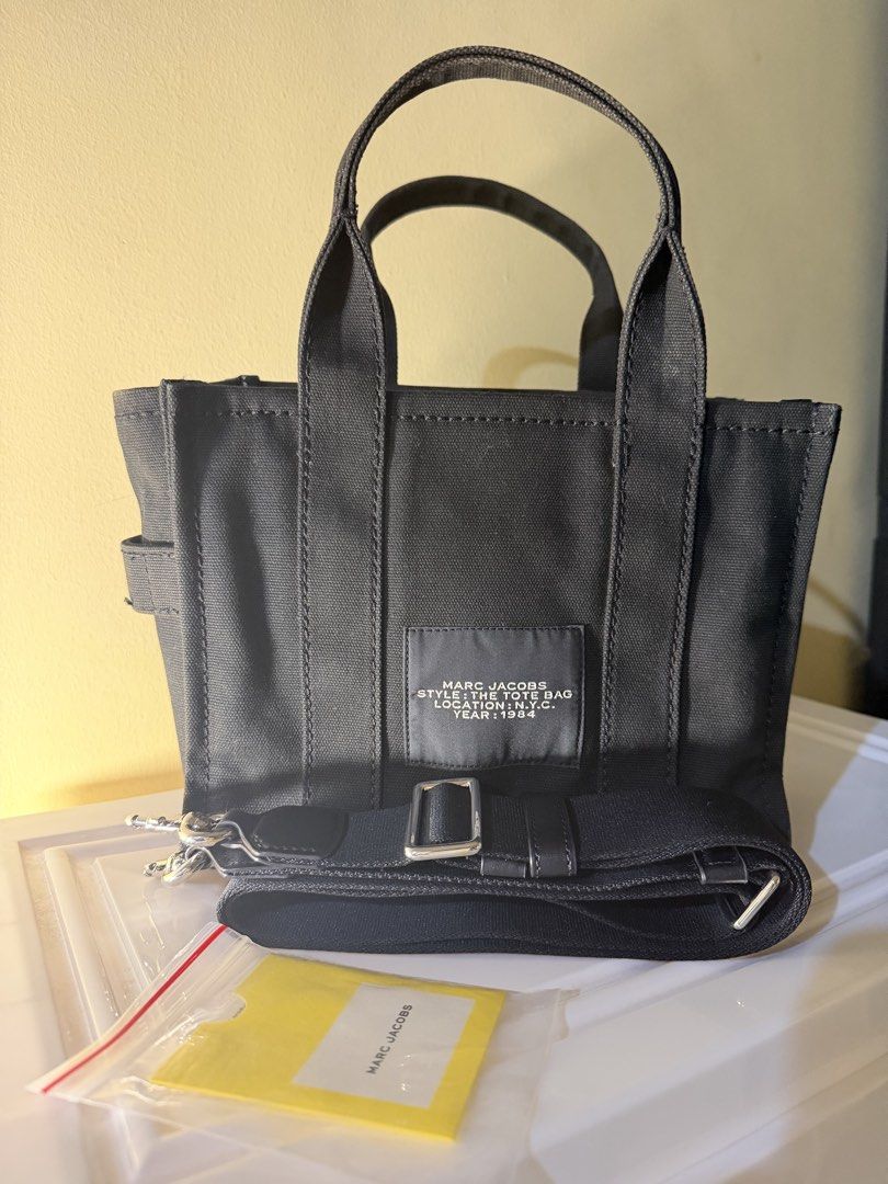 Marc Jacobs The Tote Bag Black Canvas Mini (Category: Tote Bags) located in Cebu City. Submitted by thelittlefindscbu (Listing ID 1464571543, Image 3). Description: • Brand: Marc Jacobs • Style: The Canvas Small Tote Bag • Color: Black • Size: Small • Material: Cotton canvas • With original adjustable/removable crossbody strap • Top handles + crossbody option • Zip-top closure • Classic white THE TOTE BAG / MARC JACOBS logo • Condition: Preloved 