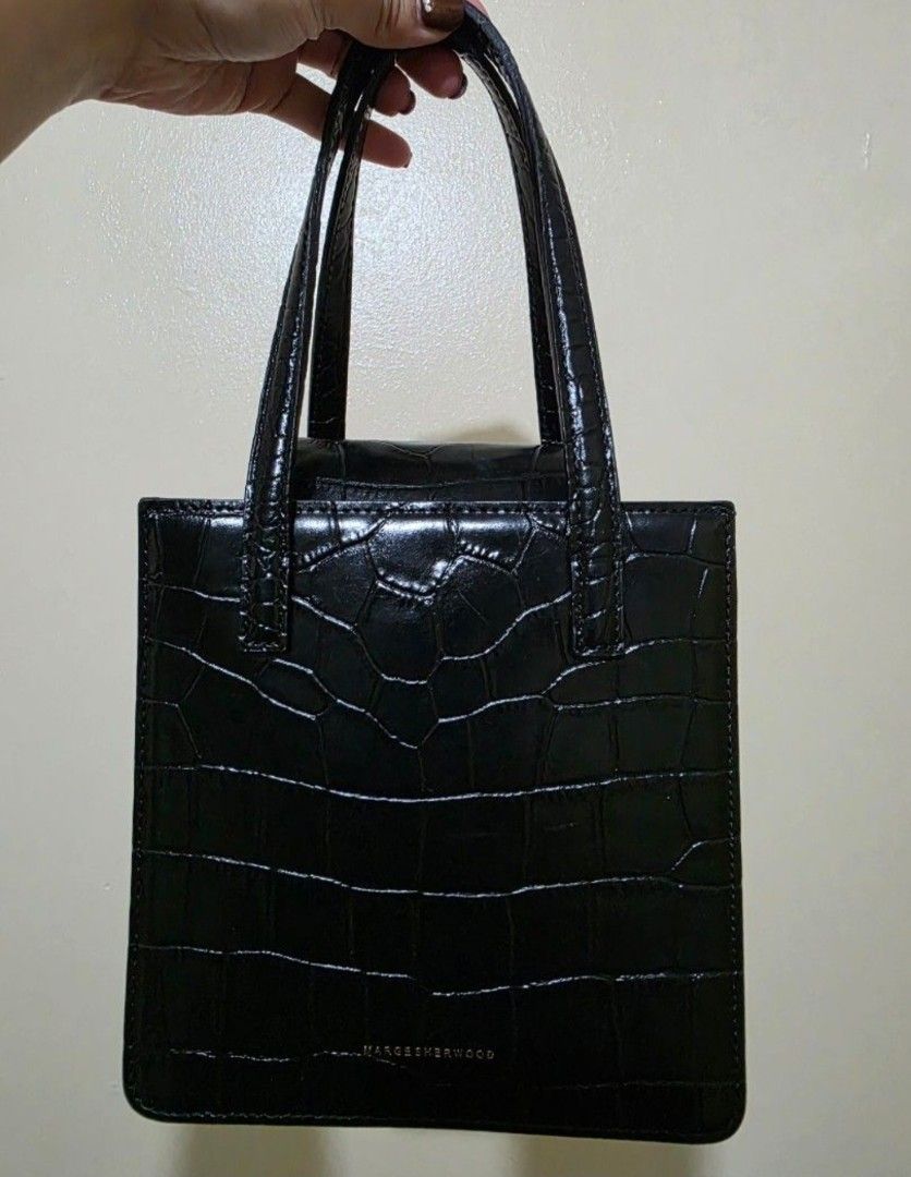 MARGE SHERWOOD Black Crocodile Mini Bag (Category: Purses & Pouches) located in Las Pinas. Submitted by andthelike (Listing ID 1464744244, Image 1). Description: - Brand: MARGE SHERWOOD - Material: Black crocodile embossed leather - Design: Structured square shape with flap closure and double top handles - Details: Gold-toned brand lettering on front - Style: Classic minimalist, highly versatile - Flaws: Minor scuff mark near one strap attachment