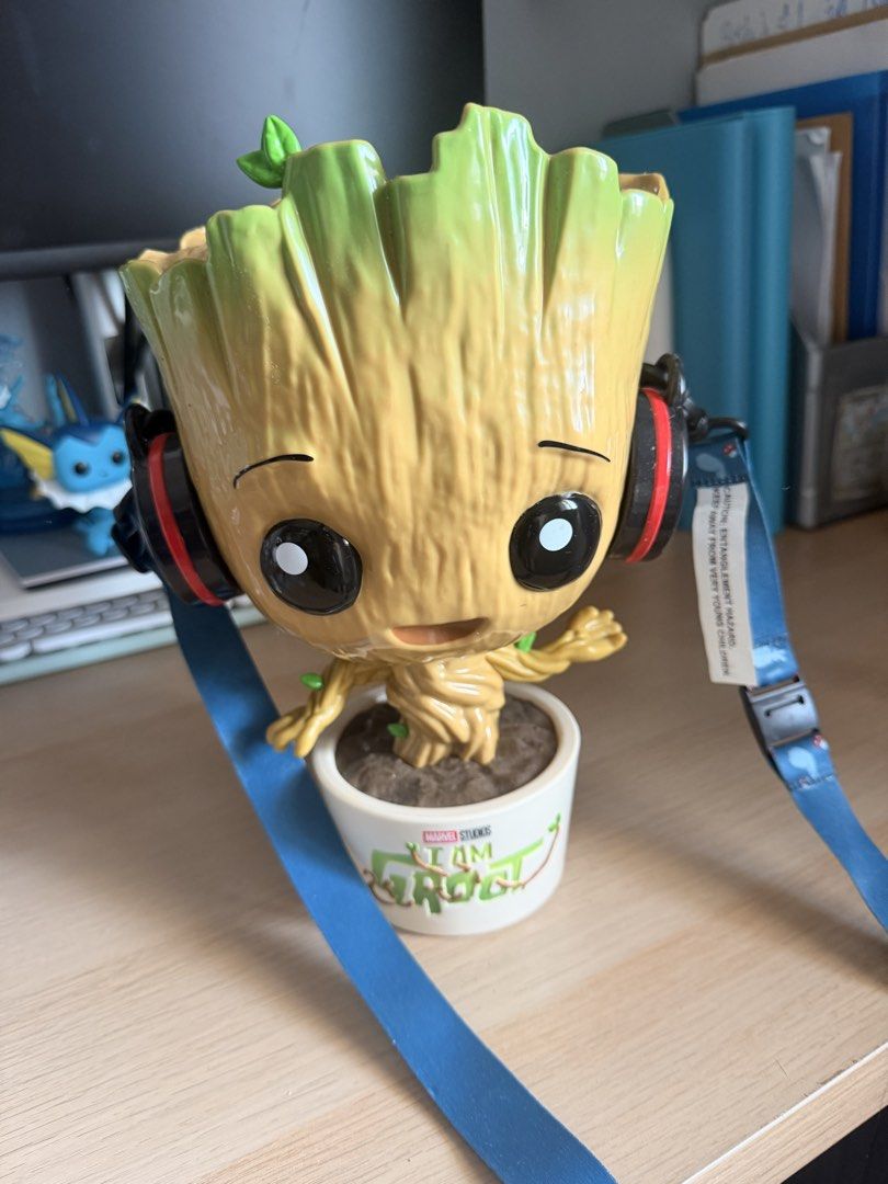 Marvel Studios I Am Groot popcorn bucket (Category: Western Merchandise) located in Manila. Submitted by ellede32655 (Listing ID 1464618948, Image 1). Description: - Adorable Groot design with headphones. - Opens to reveal storage space inside. - Base reads 'Marvel Studios I Am Groot'. - Comes with a blue lanyard. - Ideal for collecting or storing small treasures. - Batteries are not included..