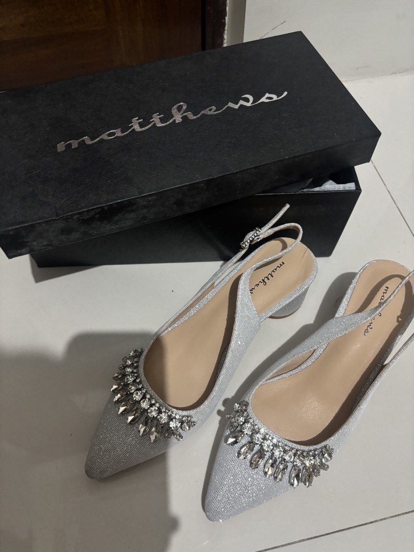 Matthews Closed Toe Heels 2-Inch Silver Size 36 (Category: Heels) located in Manila. Submitted by aysshxx (Listing ID 1464688817, Image 2). Description: - Brand: Matthews - Style: Silver glitter slingback heels with pointed toe - Details: Decorated with chunky rhinestones and crystals, adjustable back strap - Heel: Mid block heel (very manageable height) - Condition: Worn once or twice, minimal wear on soles - Packaging: Comes in original black M