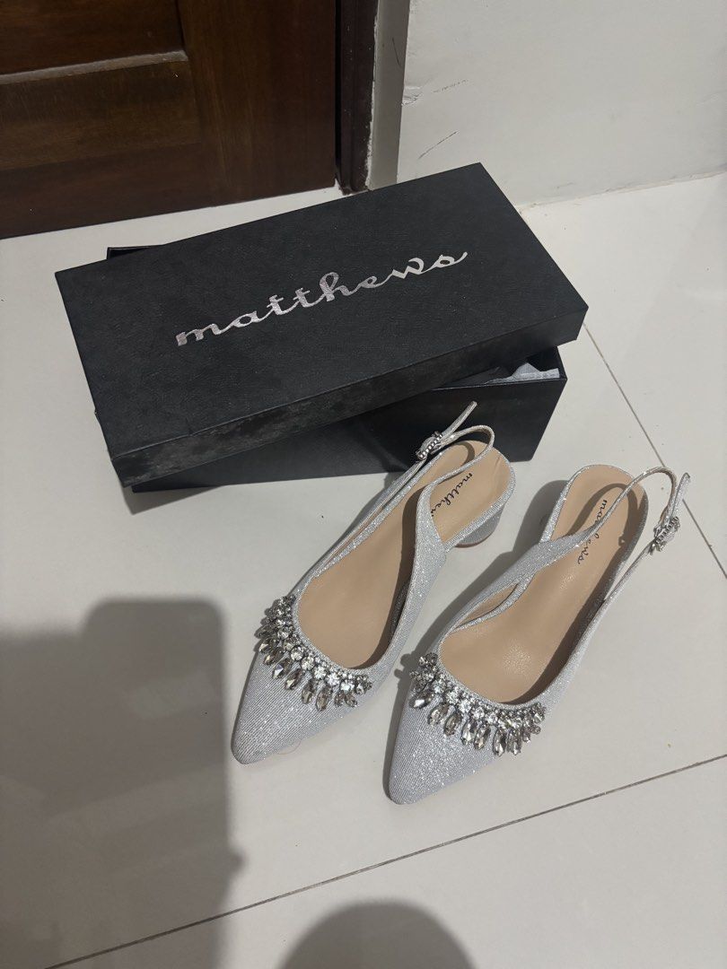 Matthews Closed Toe Heels 2-Inch Silver Size 36 (Category: Heels) located in Manila. Submitted by aysshxx (Listing ID 1464688817, Image 1). Description: - Brand: Matthews - Style: Silver glitter slingback heels with pointed toe - Details: Decorated with chunky rhinestones and crystals, adjustable back strap - Heel: Mid block heel (very manageable height) - Condition: Worn once or twice, minimal wear on soles - Packaging: Comes in original black M