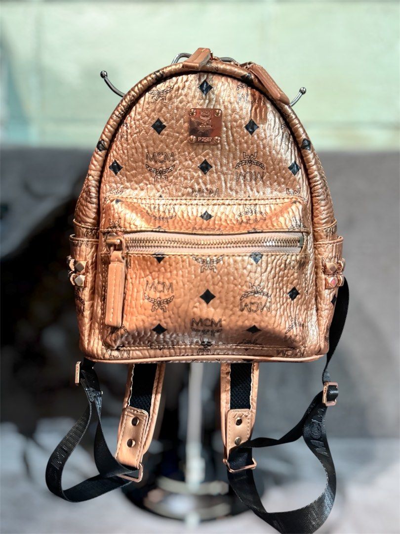 MCM Rose Gold Monogram Mini Backpack (Category: Luxury Bags & Wallets) located in Manila. Submitted by dearpinkcollections (Listing ID 1464676252, Image 1). Description: - MCM mini backpack in a chic rose gold metallic finish. - Features the signature all-over MCM monogram print. - Secure zip closure for the main compartment. - Convenient front zip pocket for essentials. - Adjustable shoulder straps for a comfortable fit. -slightly used.