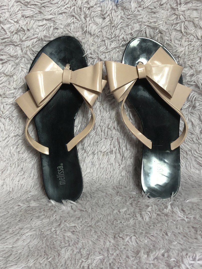 Melissa Flat Sandals Size 37 Bow Detail (Category: Flats & Sandals) located in Montevista. Submitted by rdthriftshub (Listing ID 1464656889, Image 2). Description: - Melissa flat sandals - Size: 37 - Features a cute bow detail on the strap - Soles show some signs of wear - Perfect for casual wear - Easy to slip on and off.