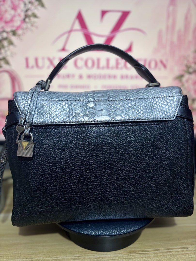Michael Kors Black & Silver Textured Leather Handbag (Category: Luxury Bags & Wallets) located in Mandaluyong City. Submitted by annaziki2001 (Listing ID 1464573073, Image 3). Description: - Michael Kors black pebbled leather handbag - Silver textured flap with twist lock closure - Top handle and detachable shoulder strap included - Multiple interior compartments and zip pockets - Michael Kors logo detail on front and inside - Original strap is i
