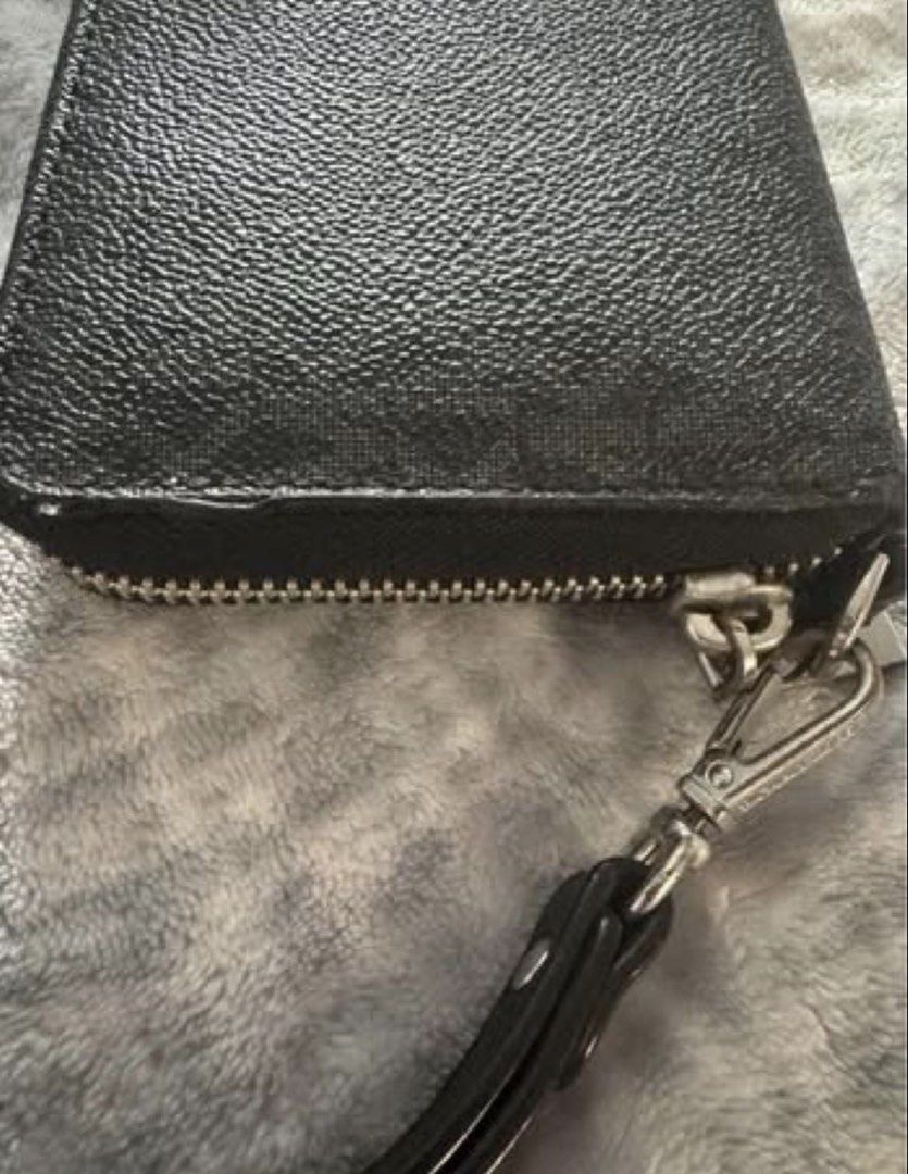 Michael Kors Black Monogram Print Zip-Around Wristlet Wallet (Category: Luxury Bags & Wallets) located in Manila. Submitted by kaia_studios (Listing ID 1464701399, Image 2). Description: - Brand: Michael Kors - Color: Classic Black with all-over MK monogram - Material: Textured leather with silver-tone hardware and brand plaque - Features: Detachable wrist strap and smooth zip-around closure - Interior: Multiple card slots, slip pockets, and a co
