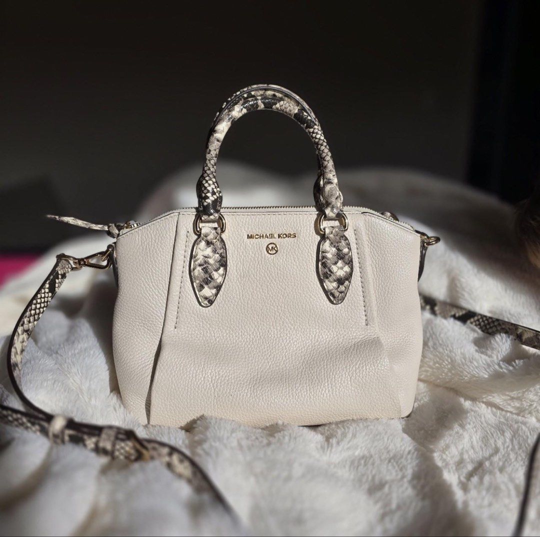 Michael Kors Cream Python Print Satchel Crossbody Bag (Category: Luxury Bags & Wallets) located in Manila. Submitted by kaia_studios (Listing ID 1464700991, Image 1). Description: Cream pebbled leather satchel with snakeskin-embossed handles and detachable crossbody strap. Gold-tone hardware and Michael Kors logo lettering on front. Zip top closure. Interior has custom fabric lining with multiple slip pockets and one zippered pocket with a leathe