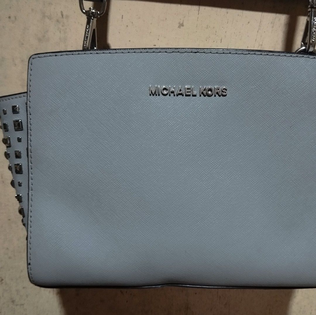Michael Kors Studded Shoulder Bag (Category: Cross-body Bags) located in Manila. Submitted by lene48 (Listing ID 1464596603, Image 2). Description: - Authentic Michael Kors shoulder bag - Elegant light grey color - Stylish silver stud details on the sides - Interior lined with signature Michael Kors logo pattern - Includes a detachable strap for versatile wear - Ideal for everyday use and adding a touch of luxury to your outfits.