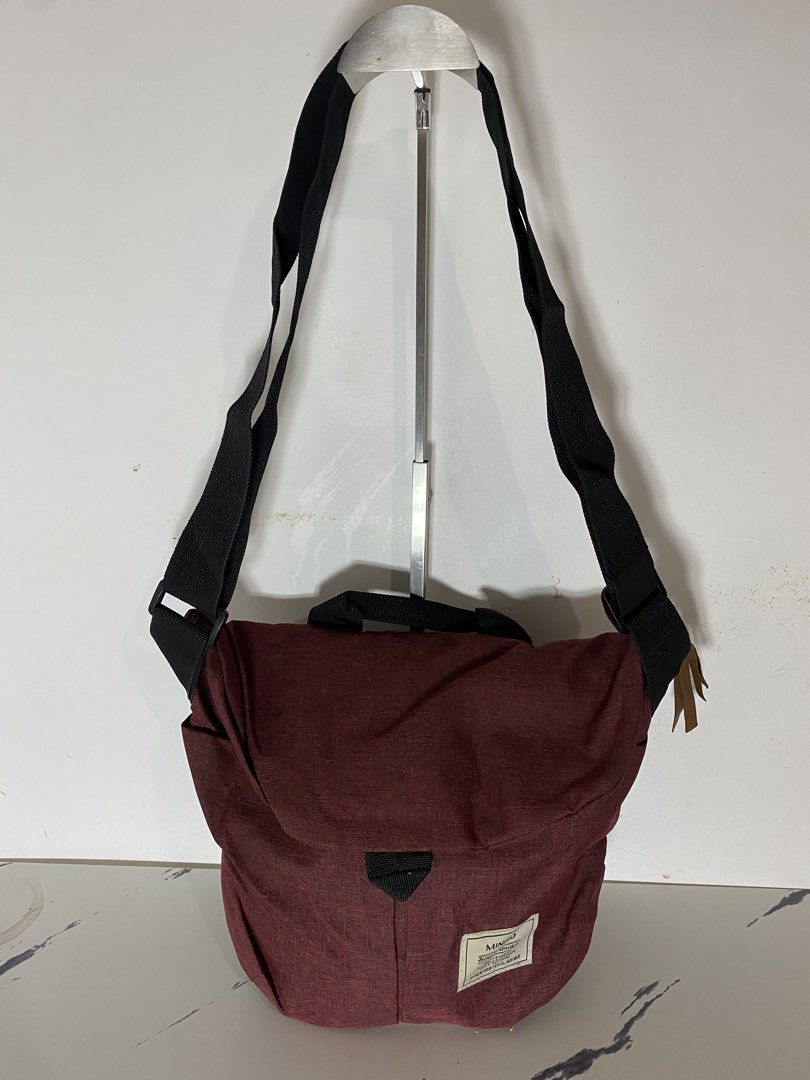 MINISO Simple Unique Crossbody Bag Maroon (Category: Cross-body Bags) located in Manila. Submitted by onfleekapparelph (Listing ID 1464719368, Image 1). Description: - Brand: MINISO - Color: Maroon - Material: Soft texture, lightweight - Closure: Flap with secure strap - Strap: Adjustable black shoulder strap - Condition: Clean inside and out - Capacity: Roomy enough for daily essentials.
