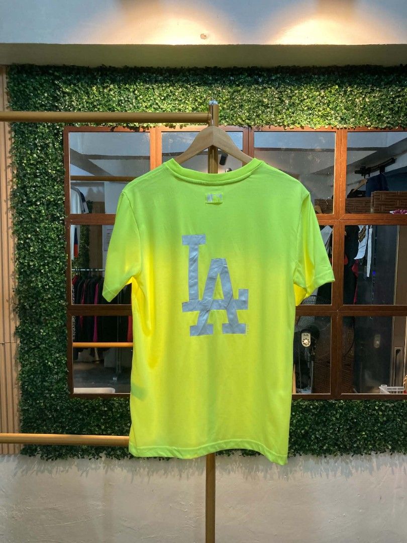 MLB LA Dodgers Neon Yellow T-Shirt (Category: Tshirts & Polo Shirts ) located in Trece Martires City. Submitted by djaothriftshop (Listing ID 1464706032, Image 1). Description: - Authentic MLB Los Angeles Dodgers neon yellow t-shirt - Embroidered team logo on the chest with a large reflective LA graphic on the back - Crew neck design with branded inner taping for added detail - Comfortable cotton and polyester blend fabric.