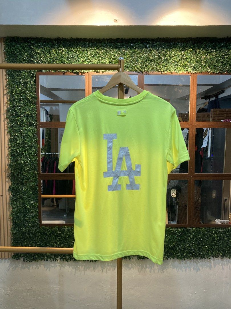 MLB LA Dodgers Neon Yellow T-Shirt (Category: Tshirts & Polo Shirts ) located in Trece Martires City. Submitted by thriftkoto.91 (Listing ID 1464765069, Image 2). Description: - Authentic MLB Los Angeles Dodgers t-shirt in bright neon yellow - Small embroidered LA logo on the front chest - Large reflective graphic logo on the back for extra style - Comfortable cotton blend material for everyday wear - Crew neck featuring printed MLB branding tape