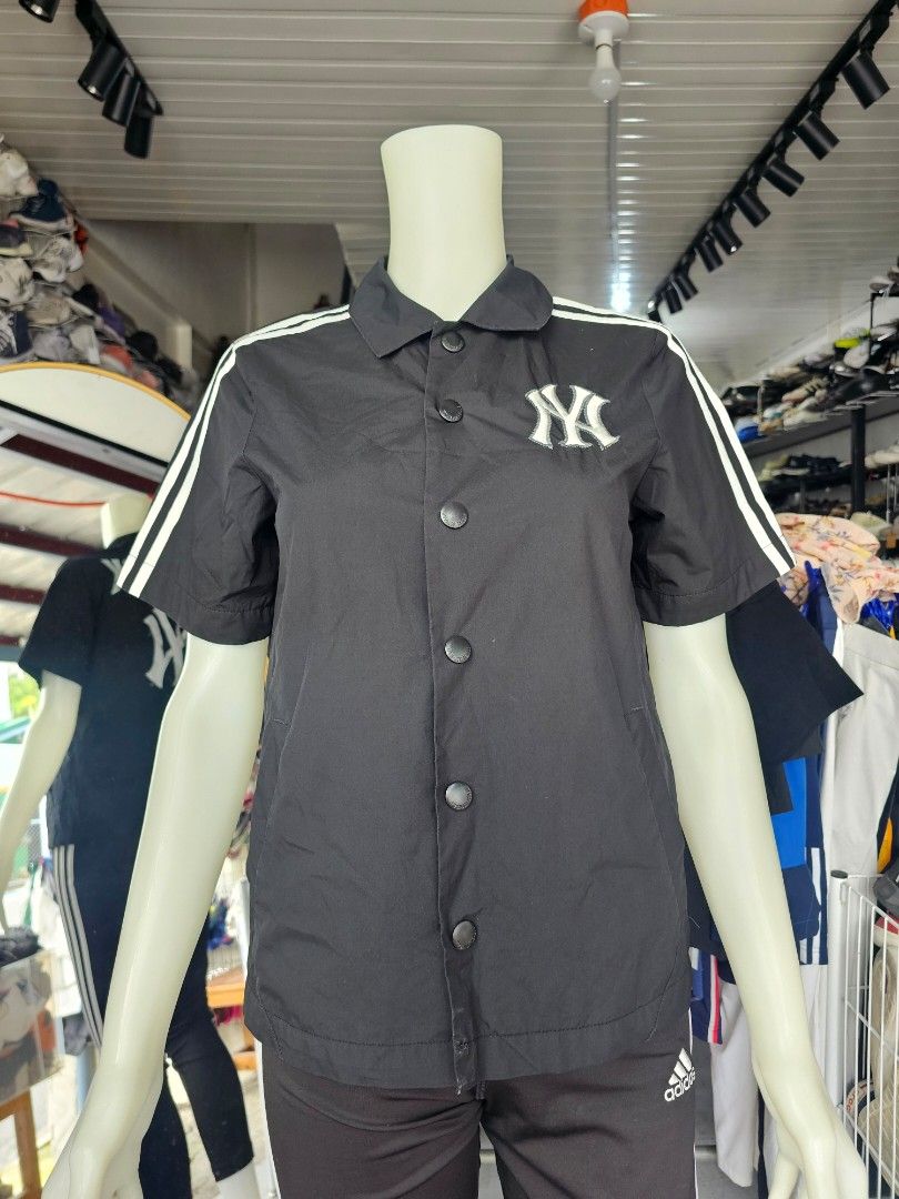 MLB New York Yankees short-sleeved baseball jacket (Category: Tshirts & Polo Shirts ) located in Baguio. Submitted by kayeonlineshop (Listing ID 1464661830, Image 1). Description: -black short-sleeve button-up shirt featuring the iconic New York Yankees logo and white shoulder stripes, similar in style to athletic coaches' jackets. - Measurements including in the photos.
