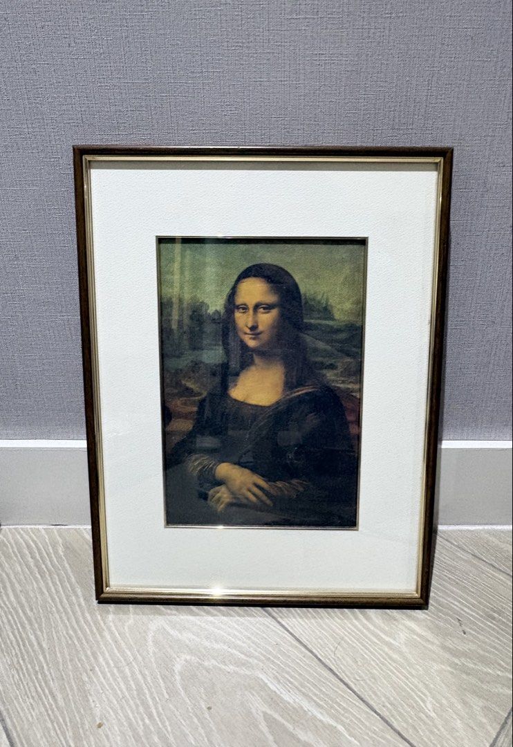 Mona Lisa Framed Print (Category: Art & Prints) located in Manila. Submitted by foundhouseph (Listing ID 1464749454, Image 1). Description: - Classic Mona Lisa print featuring timeless Renaissance art - Size: 30x39cm - Elegant dark wood-finish frame with chic metallic inner trim - Neutral off-white matting for a sophisticated look - Ready to hang with an attached white hanging cord - Clean overall appearance with minimal wear on the hardware and 