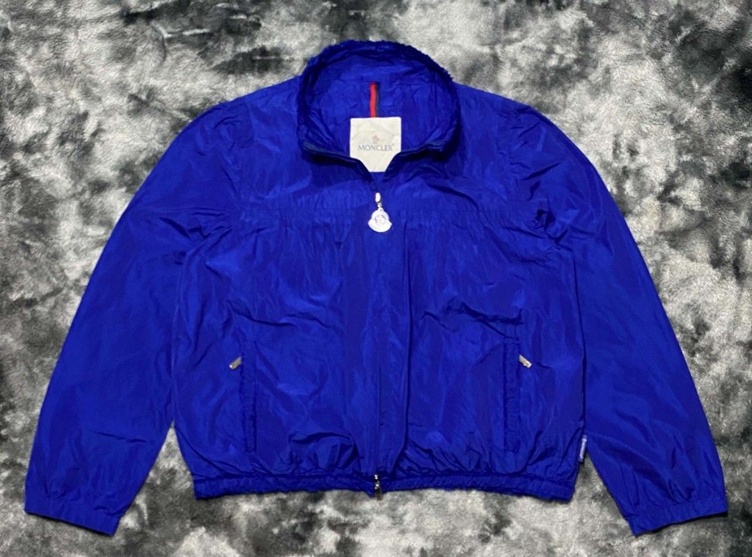 Moncler Blue Windbreaker Jacket (Category: Coats, Jackets and Outerwear) located in Sorsogon. Submitted by johnmichae69459 (Listing ID 1464641413, Image 1). Description: - Authentic Moncler windbreaker jacket in blue. - Lightweight and perfect for layering or standalone wear. - Features the iconic Moncler logo prominently on the chest. - Convenient front pockets for essentials. - Secure fit with elasticated cuffs and hem. - Distinctive Moncler lo