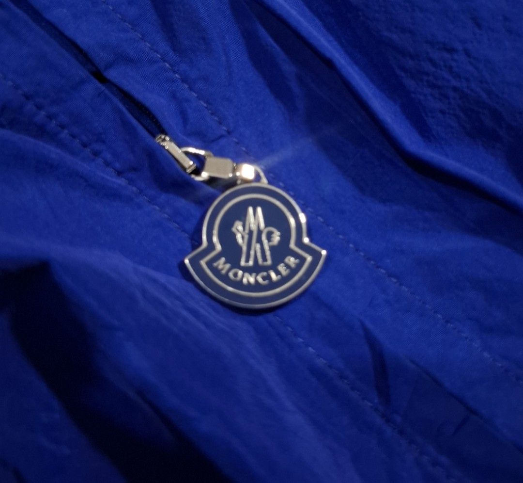 Moncler Blue Windbreaker Jacket (Category: Coats, Jackets and Outerwear) located in Sorsogon. Submitted by johnmichae69459 (Listing ID 1464641413, Image 2). Description: - Authentic Moncler windbreaker jacket in blue. - Lightweight and perfect for layering or standalone wear. - Features the iconic Moncler logo prominently on the chest. - Convenient front pockets for essentials. - Secure fit with elasticated cuffs and hem. - Distinctive Moncler lo
